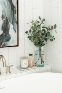 builtin shelf behind tub faucet decor bath salts eucalyptus leaves art